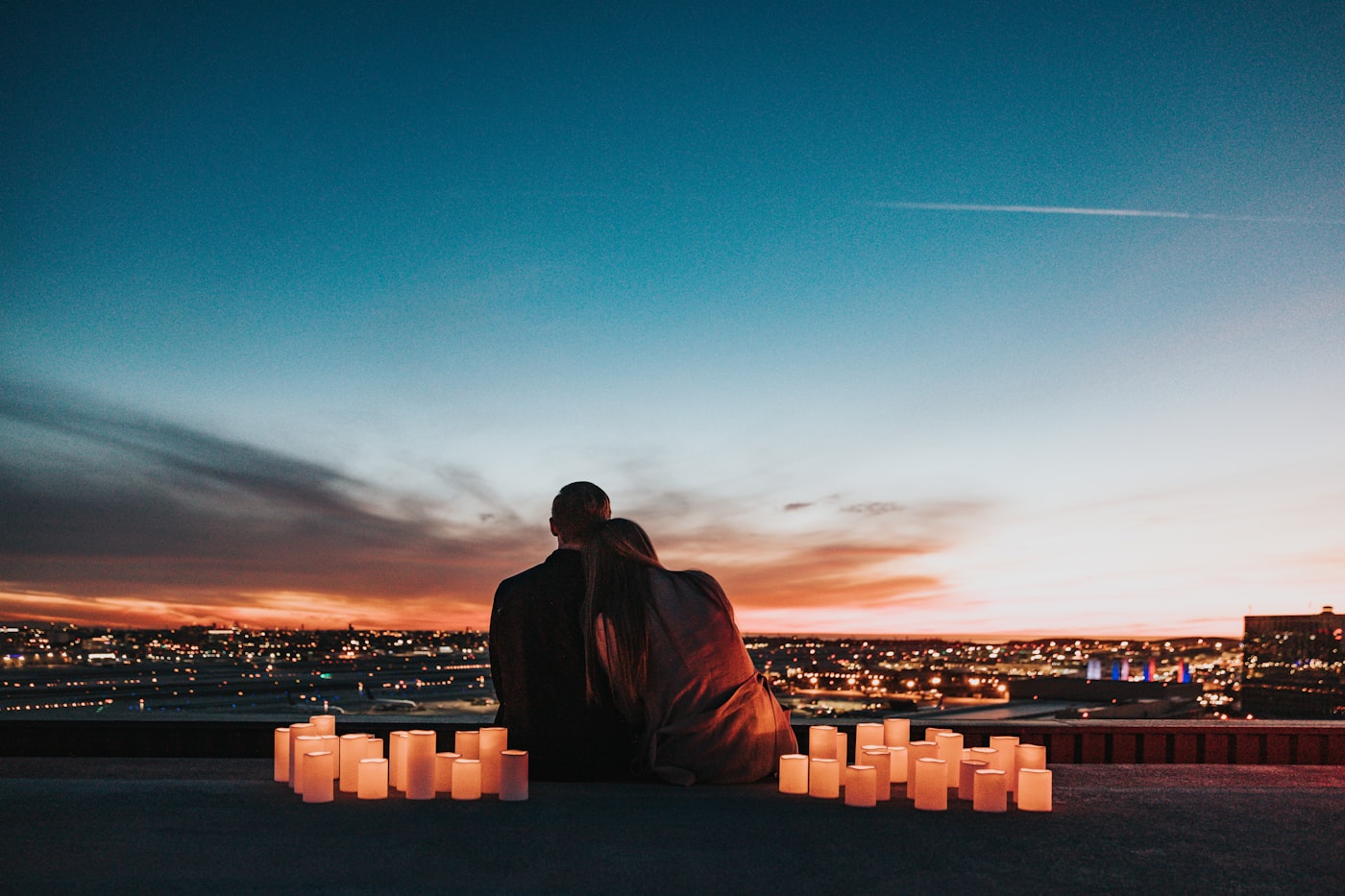 Casal admirando as luzes da cidade ao anoitecer